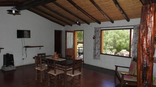a dining room with a table and chairs and a window at Pircas del Abuelo in Tilcara