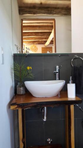 a white sink on a wooden counter in a bathroom at Dharma in Punta Del Diablo