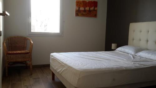 1 dormitorio con 1 cama, 1 silla y 1 ventana en Ressourcez vous en pleine nature! en Saint-Régis-du-Coin
