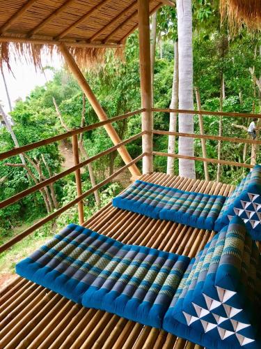 a group of blue benches sitting on a deck at Kalulushi Bungalows in Haad Pleayleam