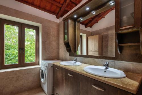a bathroom with two sinks and a washing machine at Flabouriaris Estate in Anafonítria