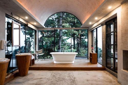 baño grande con bañera y ventanas grandes. en Casa Prana Hotel in Atitlan, en Santa Cruz La Laguna