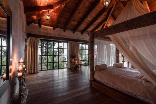 a bedroom with a bed in a room with windows at Casa Prana Hotel in Atitlan in Santa Cruz La Laguna