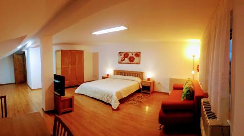 Un dormitorio con una cama, un televisor y un sofá. en Villa Sanitas, en Techirghiol