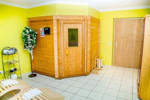 a room with a wooden door and yellow walls at Waldhotel Friedrichroda in Friedrichroda