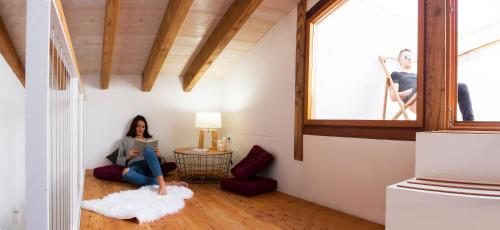 a woman sitting on the floor in a room at Can Girmas Casa de Turisme rural Navata in Navata
