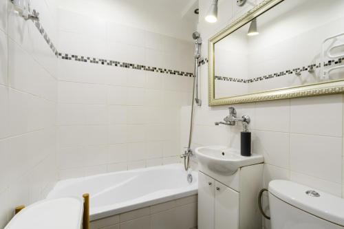 ein Badezimmer mit einer Badewanne, einem Waschbecken und einem WC in der Unterkunft Labo Apartment Muranów in Warschau
