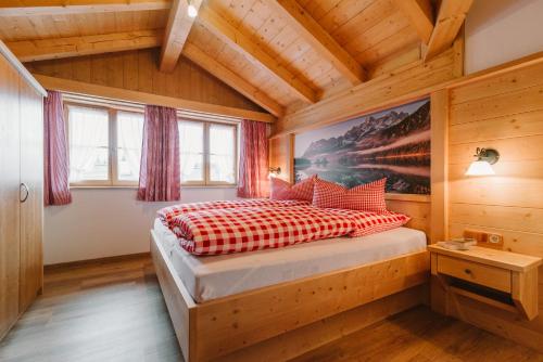 ein Schlafzimmer mit einem Bett in einem Holzhaus in der Unterkunft Haus am Kramer in Garmisch-Partenkirchen