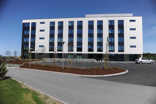 a large building with a parking lot in front of it at Tananger Apartment Hotel in Tananger