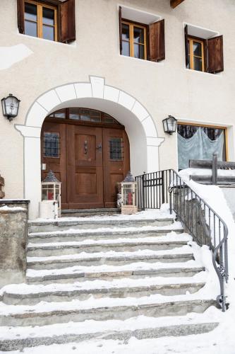 a set of stairs in front of a building with a door at Meisser Lodge in Guarda