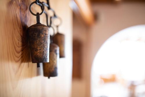 a group of bells hanging on a wall at Meisser Lodge in Guarda