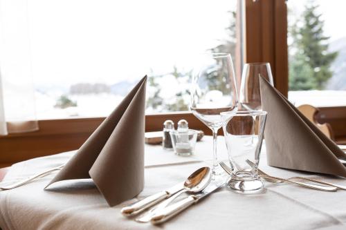 a table with wine glasses and napkins on a table at Meisser Lodge in Guarda