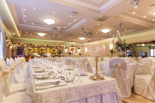 a banquet hall with white tables and white chairs at Flagstaff Lodge in Newry