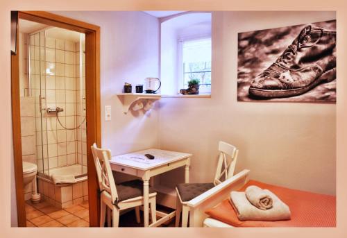 een badkamer met een tafel en 2 stoelen en een douche bij Alte Scheune Flemmingen in Flemmingen