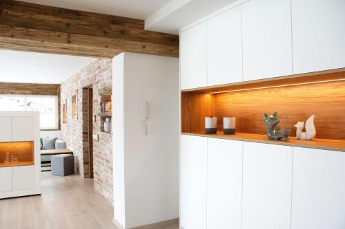 a kitchen with white cabinets and a brick wall at Mountainlodge by Skischule Hermann Maier in Flachau