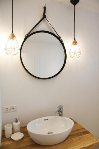 a bathroom sink with two lights and a mirror at Mountainlodge by Skischule Hermann Maier in Flachau