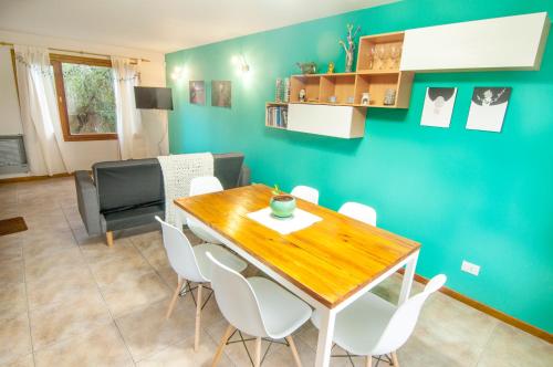 comedor con mesa de madera y sillas blancas en Casa Neneo Bariloche 2 en San Carlos de Bariloche