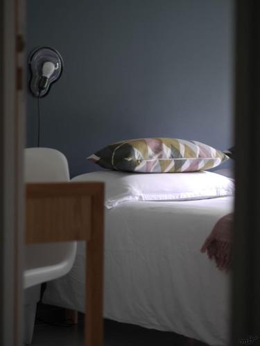 a bedroom with a bed with a pillow and a lamp at la maison dans les bois in Oudon