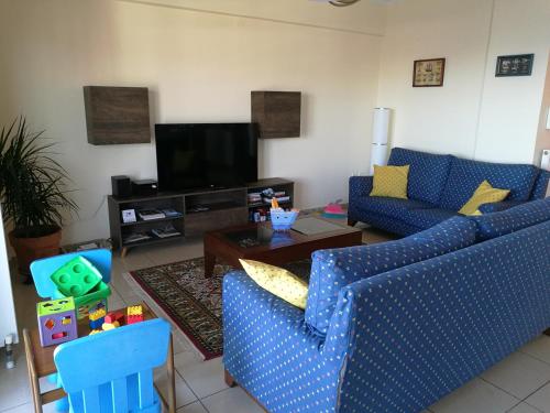 テッサロニキにあるSeafront Family Apartment & free parking, the Cruiseflatの青いソファ2つとテーブルのあるリビングルーム