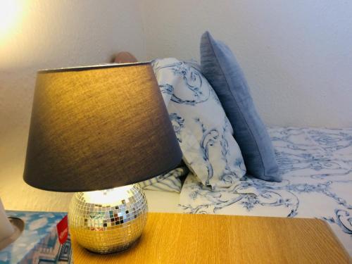 a lamp on a table next to a bed at Arden House in Arundel