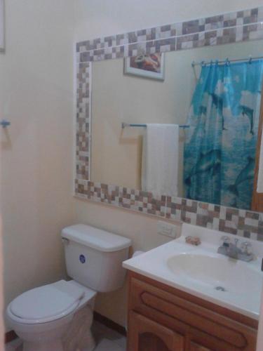 a bathroom with a toilet and a sink and a mirror at Sea Shell Palms, Ocho Rios in Ocho Rios