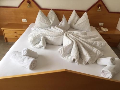 ナトゥルノにあるPension Nadineのベッド(白い毛布、タオル付)