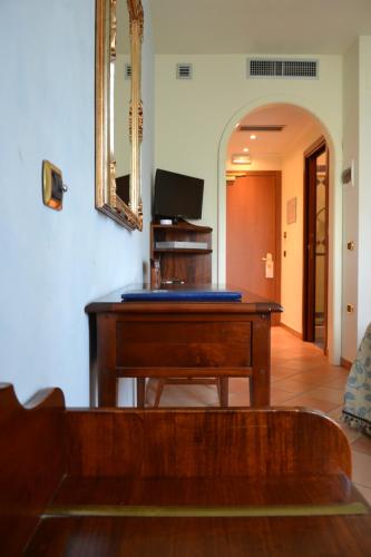 a wooden desk in a living room with a mirror at Villa Luigi Hotel & Restaurant Nuova gestione in Martinsicuro