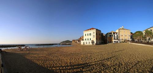 a group of people walking on a sandy beach at Palazzo Iaquinto in Santa Maria di Castellabate