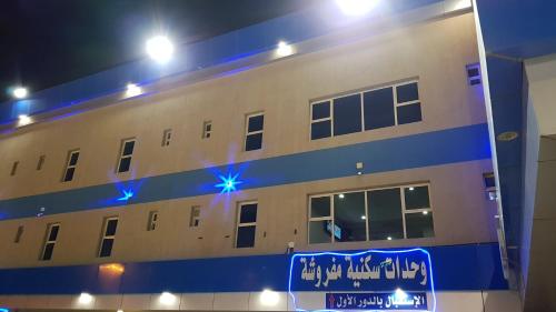 a building with blue lights on the side of it at Sanabel Al Mish'an Furnished Units in Al Jithāmīyah