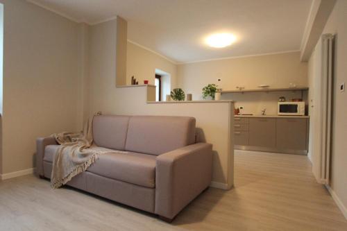 ein Wohnzimmer mit einem Sofa und einer Küche in der Unterkunft Casa Vacanze 'Lo Spirito Del Monte' in Capo di Ponte