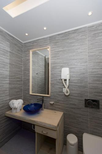 a bathroom with a blue sink and a mirror at Anthemis Hotel Apartments in Samos