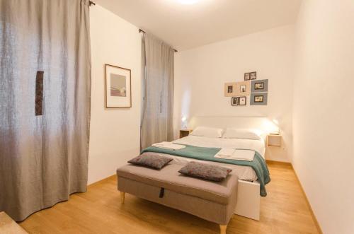a white bedroom with a bed and a window at Acquaderni 109 in Bologna