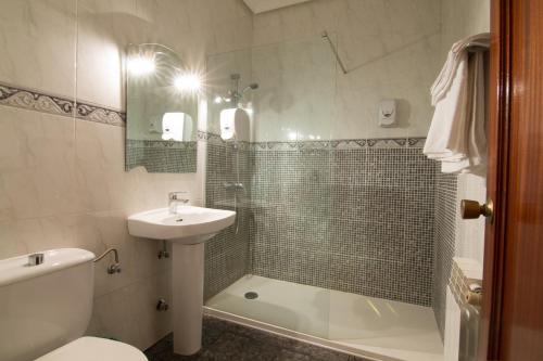 a bathroom with a toilet and a sink and a shower at Hostal Santa Ana in Madridejos