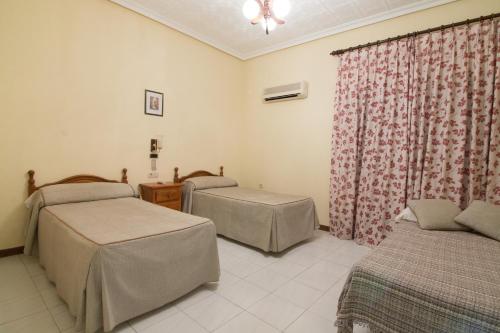 a hospital room with two beds and a window at Hostal Santa Ana in Madridejos