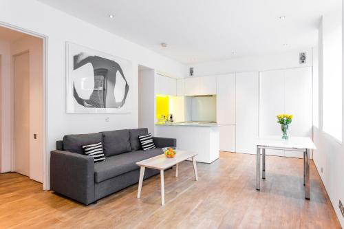 sala de estar con sofá y mesa en Oxford Circus Designer Apartment en Londres