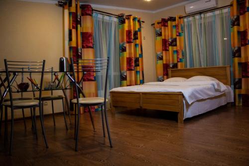 ウラジカフカスにあるGuesthouse U Dorogiのベッドルーム(ベッド1台、椅子、カーテン付)