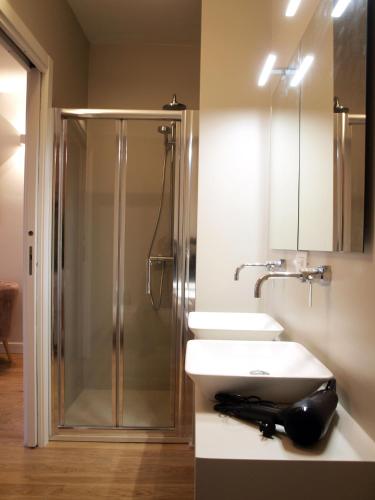 a bathroom with two sinks and a shower at Cosmopolitan Central Rooms in Bologna