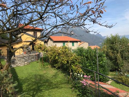 ein Haus mit einem Zaun und einem Garten mit Blumen in der Unterkunft Casa delle Rose in Faggeto Lario 