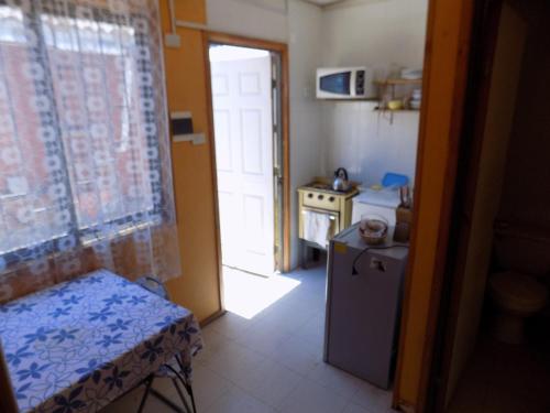 a kitchen with a door open to a kitchen with a refrigerator at Alojamiento económico a pasos del Jumbo! in La Serena