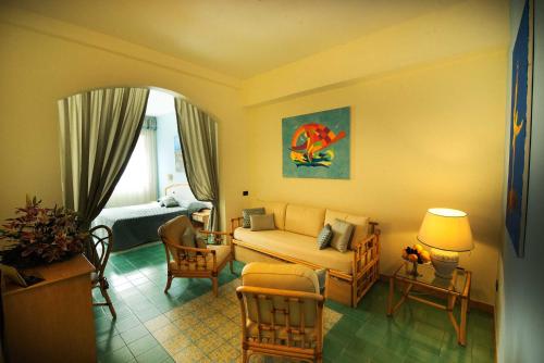 a living room with a couch and a chair at Grand Hotel Il Ninfeo in Gaeta