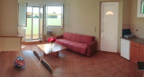 a living room with a red couch and a table at Sungate Beach in Rovies