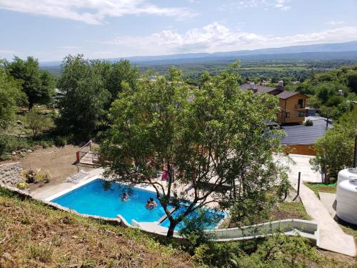 a swimming pool in a hill with a tree at Balcon de los Molles in Santa Rosa de Calamuchita
