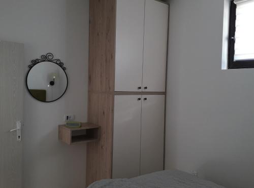 a bedroom with white cabinets and a mirror at Apartman D52 Dvori in Kopaonik