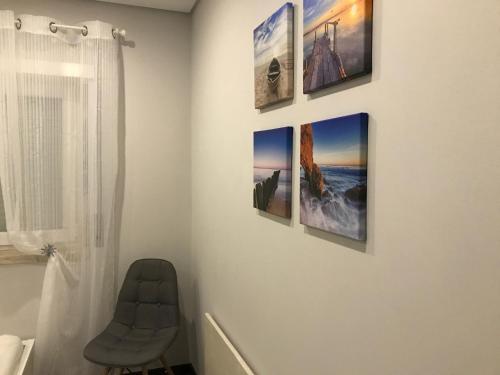 a room with four pictures on a wall at Atlantic Surf Apartment in Ferrel