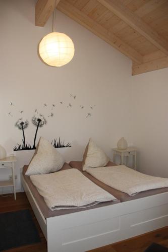 a bedroom with two beds and a light fixture at Ferienwohnungen Rimsting am Chiemsee in Rimsting