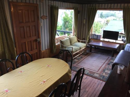 a living room with two tables and a chair and a couch at Cabaña Hagemann in Puerto Varas