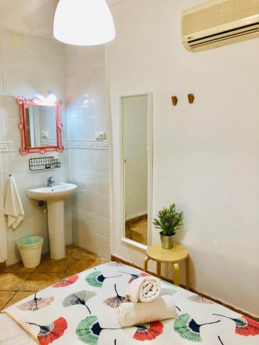 a bathroom with a bed and a sink and a mirror at Pensión La Cantarera in Cádiz