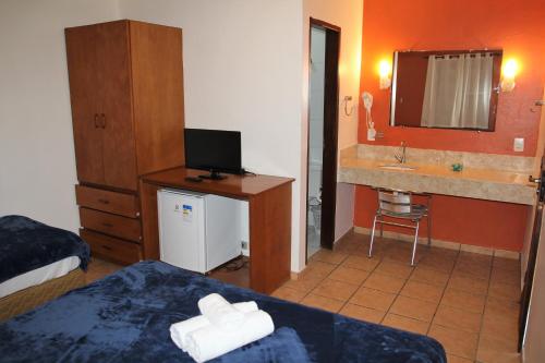 a hotel room with a bed and a sink at Porto Grande Hotel & Convention in São Sebastião