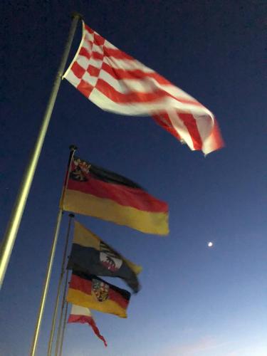 three flags are flying in the sky at Heeren's Hotel Garni in Bensersiel