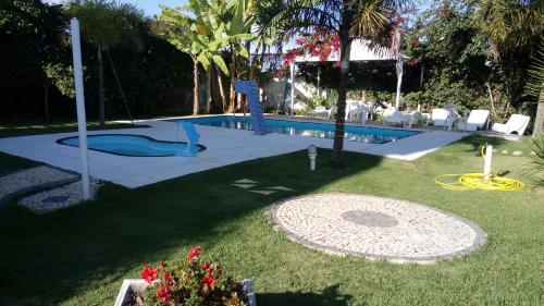 a pool with a slide in a yard with chairs at 6 Casa Juiz Fora-Novo Horizonte in Juiz de Fora